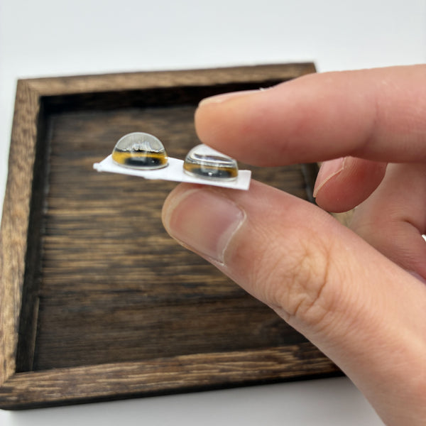 Vue de profil des yeux en verre vert olive 10 mm : dôme en verre bombé fait main
