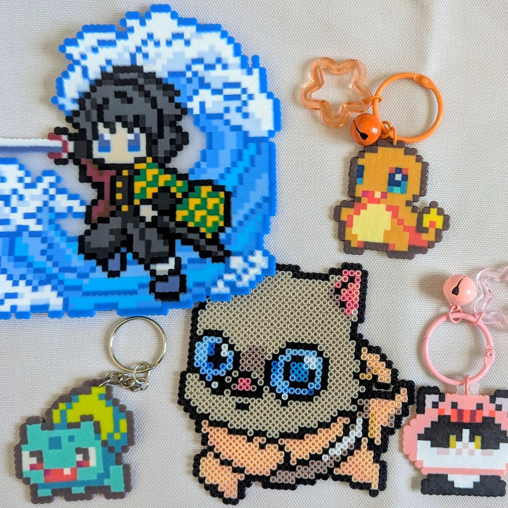 Pixel art keychains of various characters on a white background