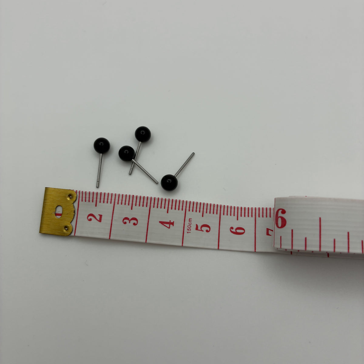 4mm 黑色针眼放在软尺旁，展示尺寸